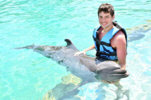 chico nadando con un delfin