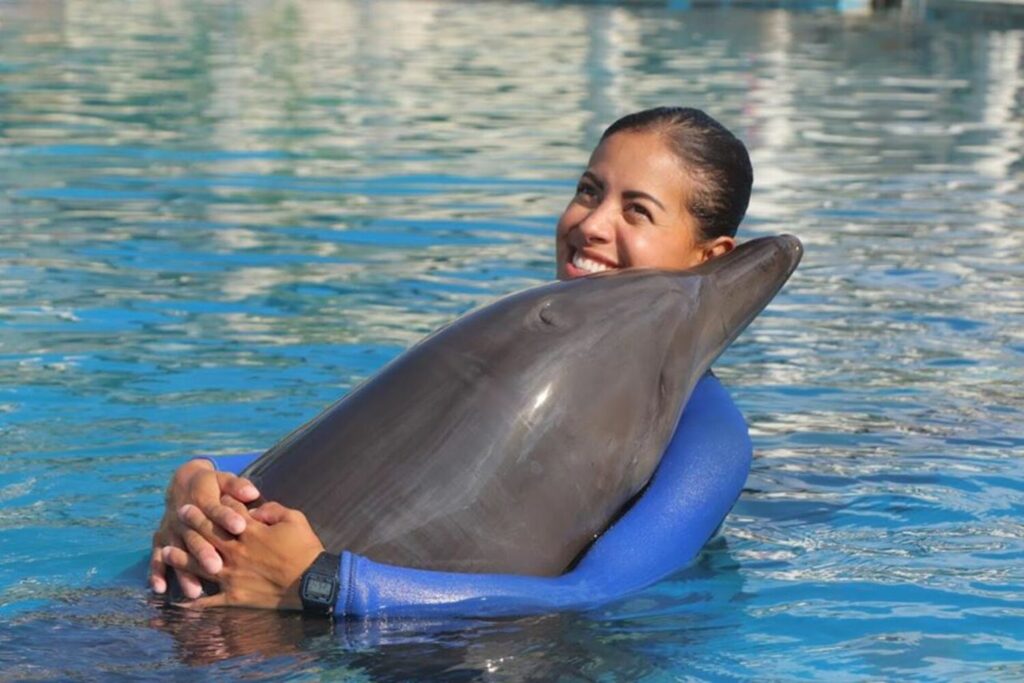 mujer abrazando a un delfin